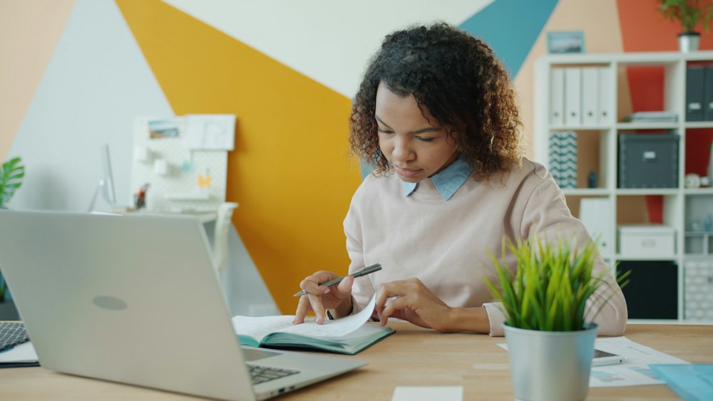 A learner working through her notes at a desk